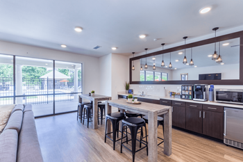 A modern kitchen with a bar area and a view of the backyard.